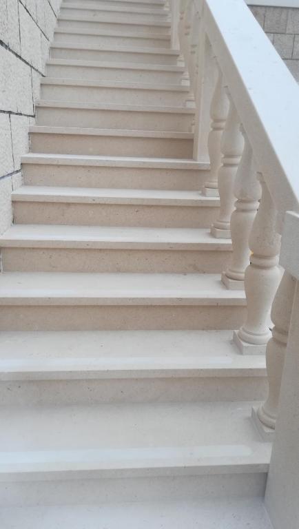 a stairway with white stairs and a white railing at Apartman Ružica in Pučišća