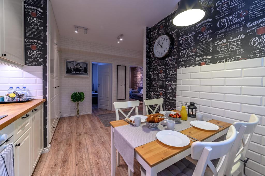 a kitchen and dining room with a table and chairs at Max Apartment Gdynia in Gdynia