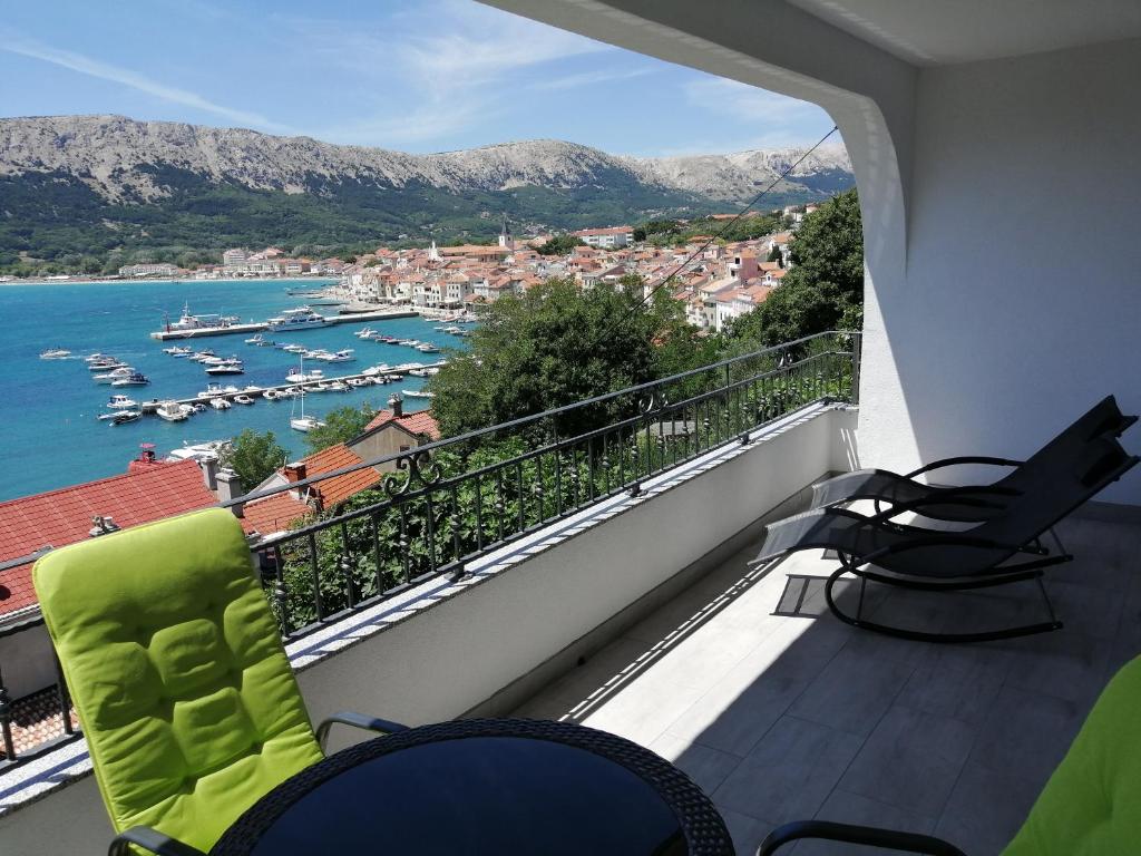 a balcony with chairs and a view of a harbor at Apartments Andrea in Baška