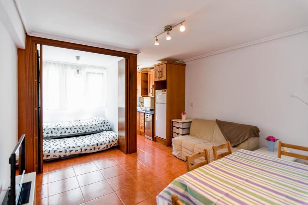 a living room with a bed and a couch at ¡Nuevo! Apartamento para 4 en playa de la Concha en Suances in Suances