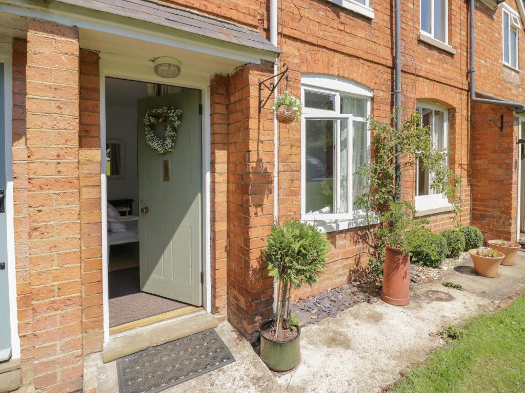 a front door of a brick house with potted plants at Meadow View in Banbury