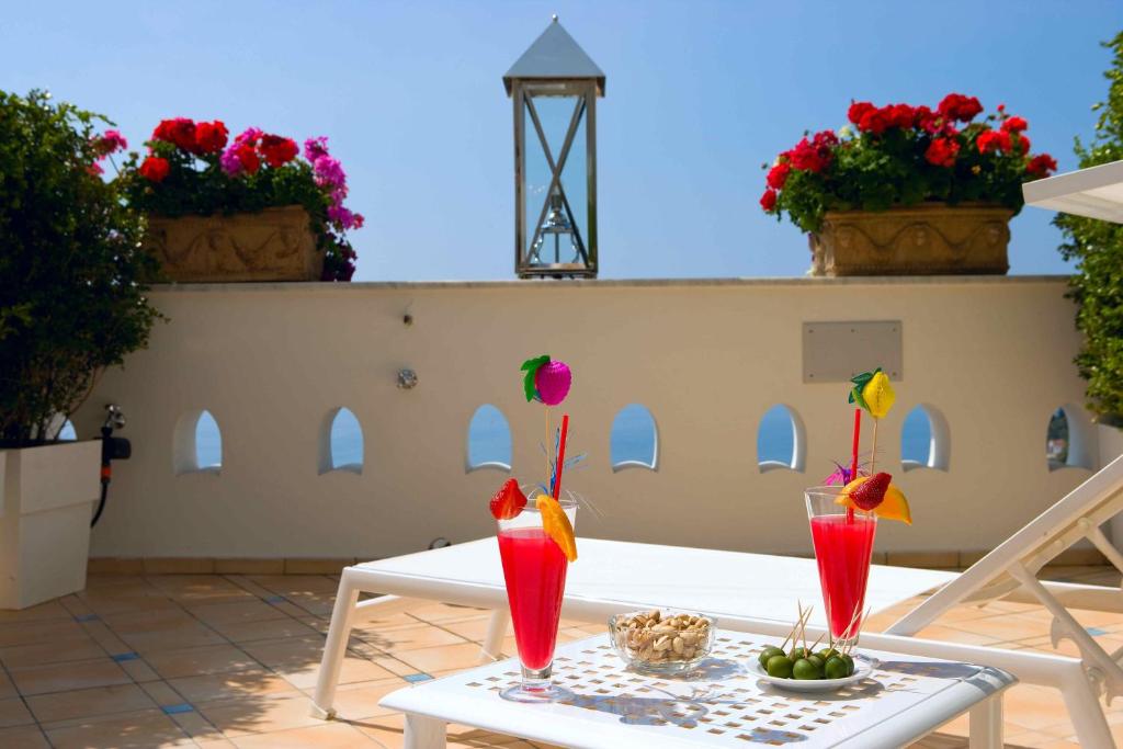 a table with two cocktails on a patio at Palazzo Marzoli charme Resort - Small Luxury Hotel in Positano