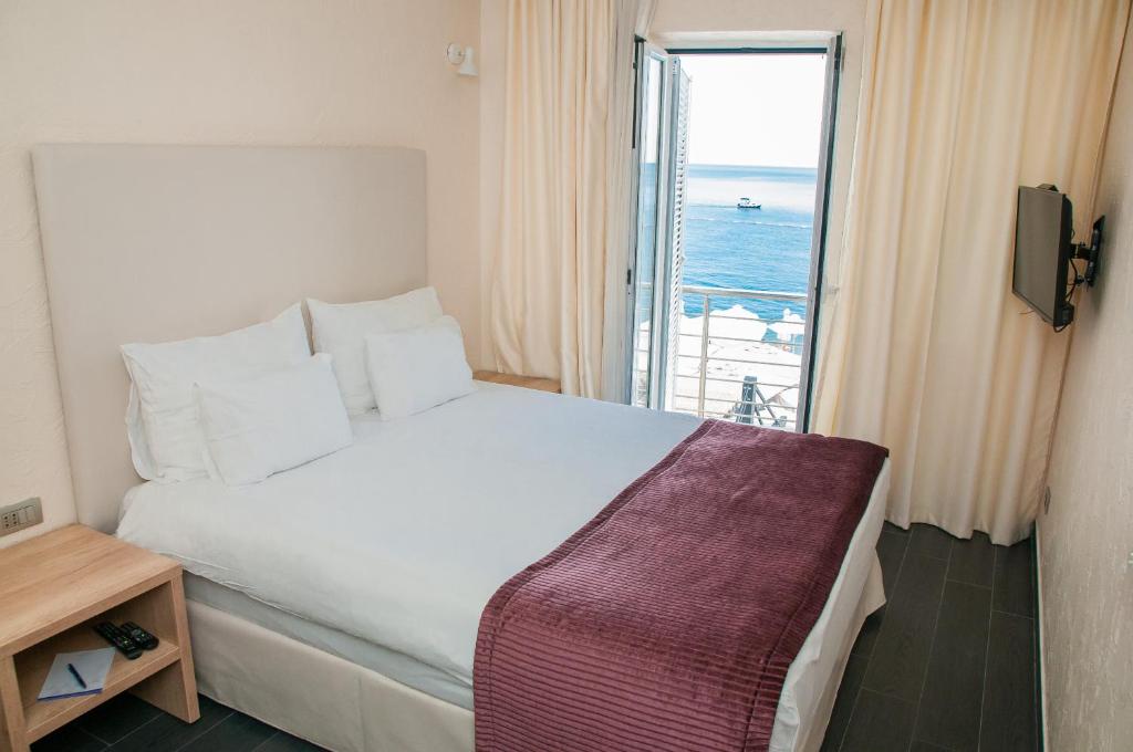 a bedroom with a large bed with a view of the ocean at Hotel Astoria in Budva