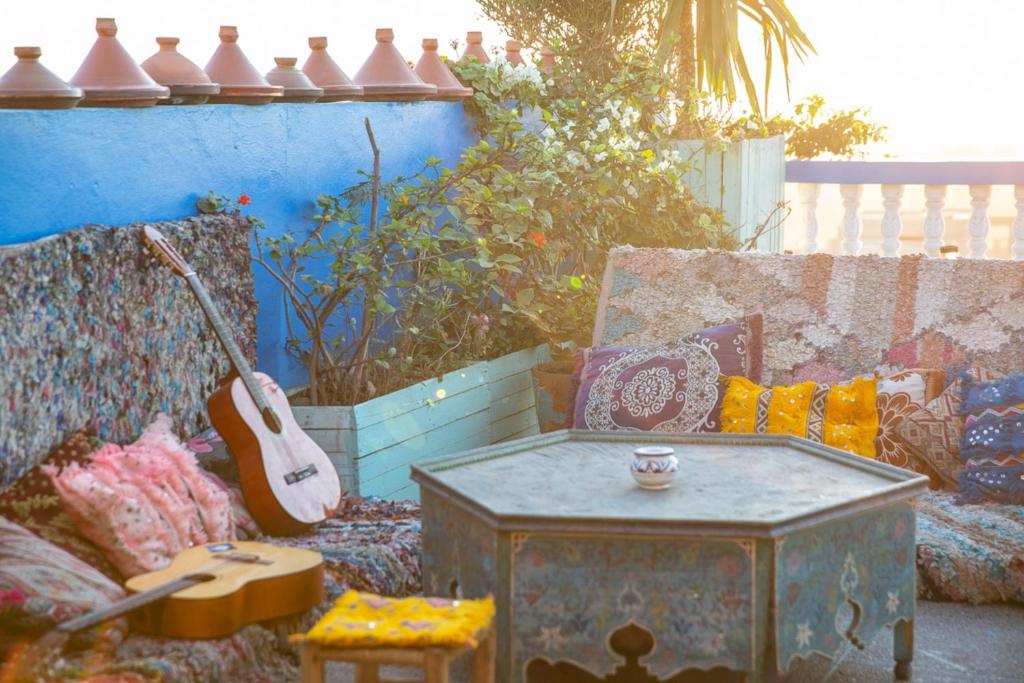 uma sala de estar com um sofá e uma guitarra em The Lunar Surf House em Tamraght Ouzdar