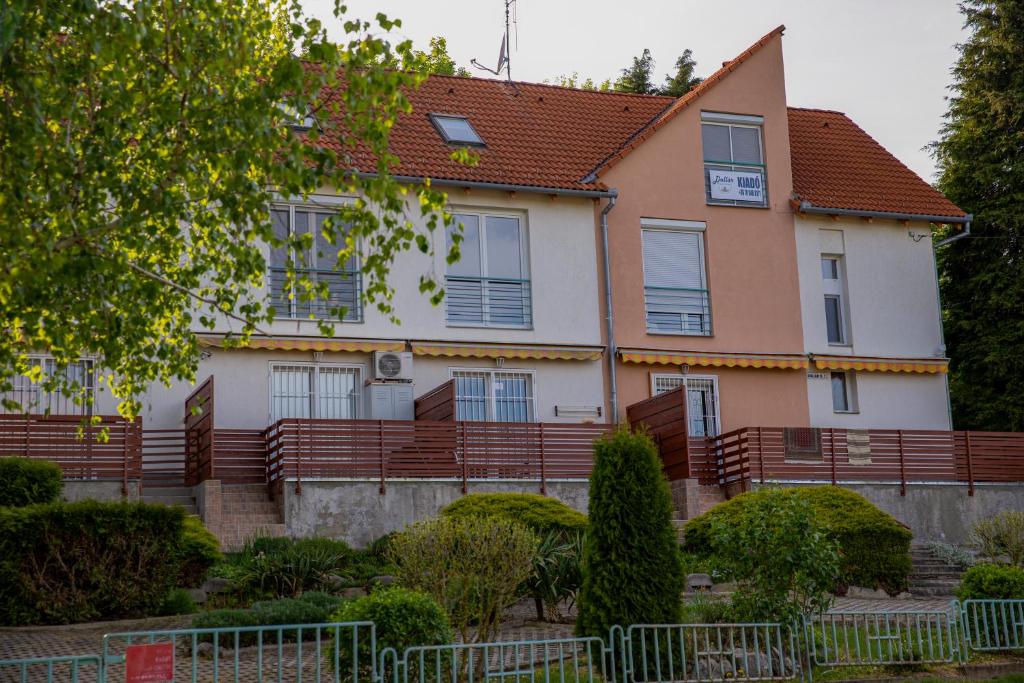 una casa con una valla delante de ella en Dollár Apartman en Orfű