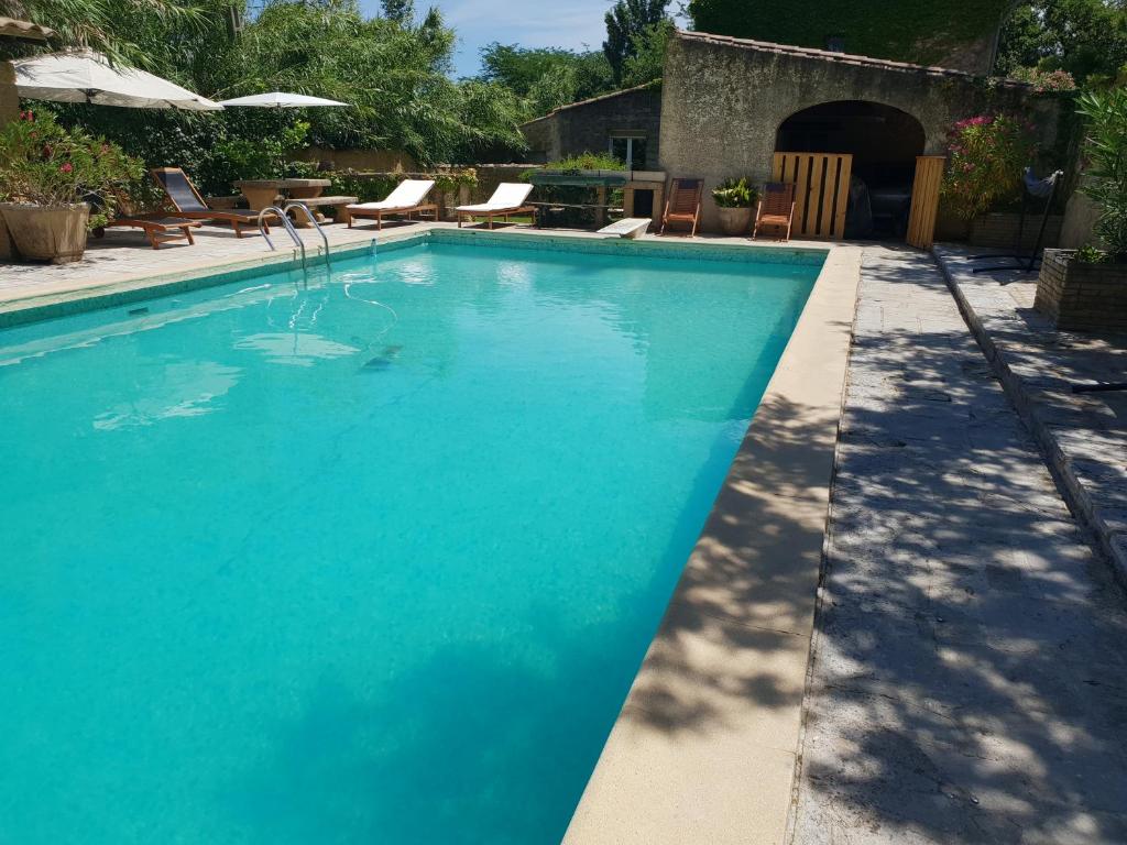 una piscina de agua azul en un patio en Mas provençal à proximité du Pont Du Gard, en Sernhac