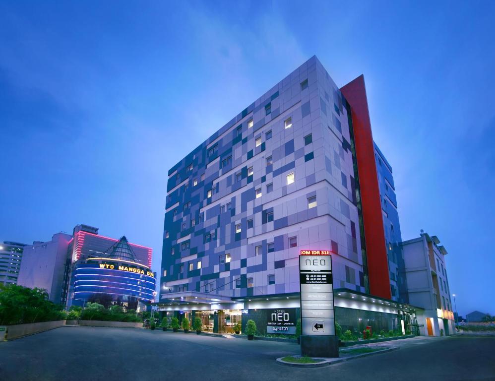 a tall building with a sign in front of it at Neo Hotel Mangga Dua by ASTON in Jakarta