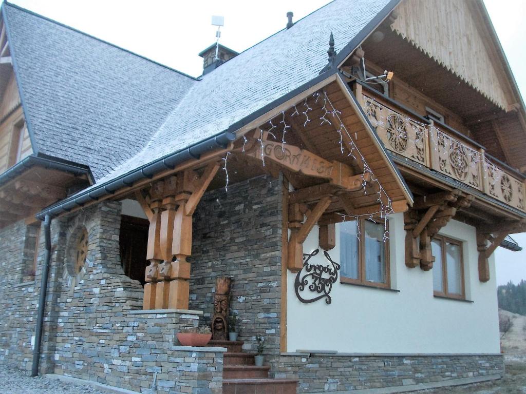 a house with a porch with wooden beams at Goramiba in Jurgów