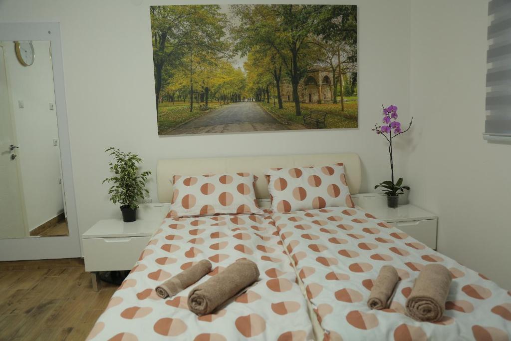 1 dormitorio con 1 cama con una pintura en la pared en Exact Apartments en Niš