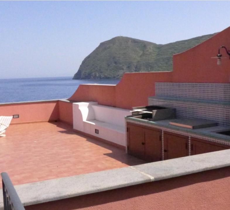 una cocina en la azotea de un edificio junto al océano en Casa Calandra, en Canneto