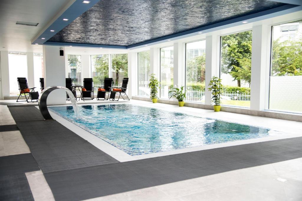 a large pool with a water slide in a building at Hotel Villa Elsa in Bad Kissingen