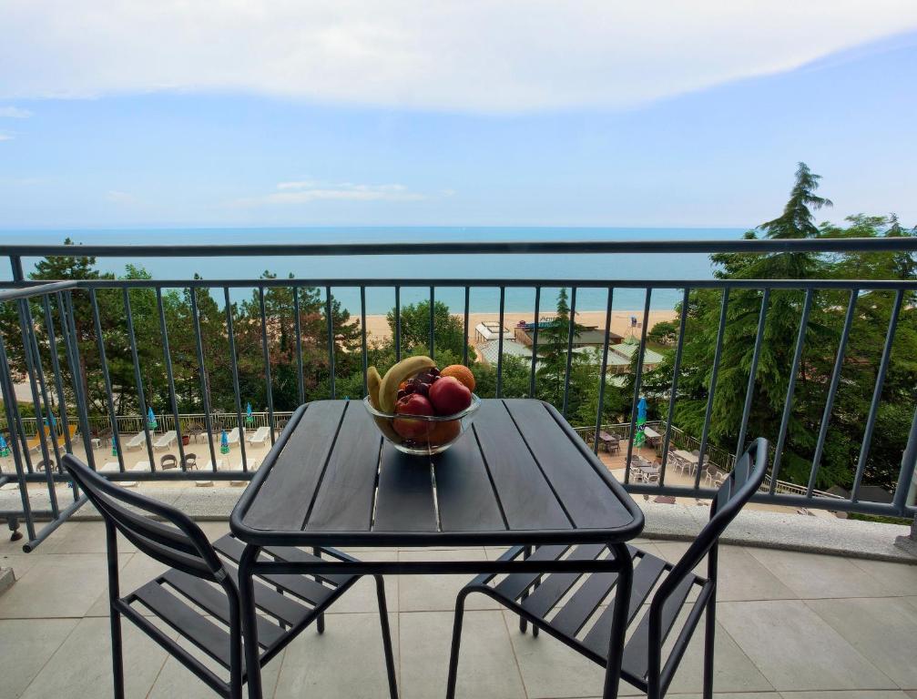 a table with a bowl of fruit on a balcony at Luna Beach Hotel - Half Board & All Inclusive in Golden Sands