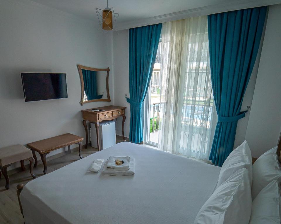 um quarto com uma cama, uma mesa e uma janela em Green Boutique Selimiye em Selimiye