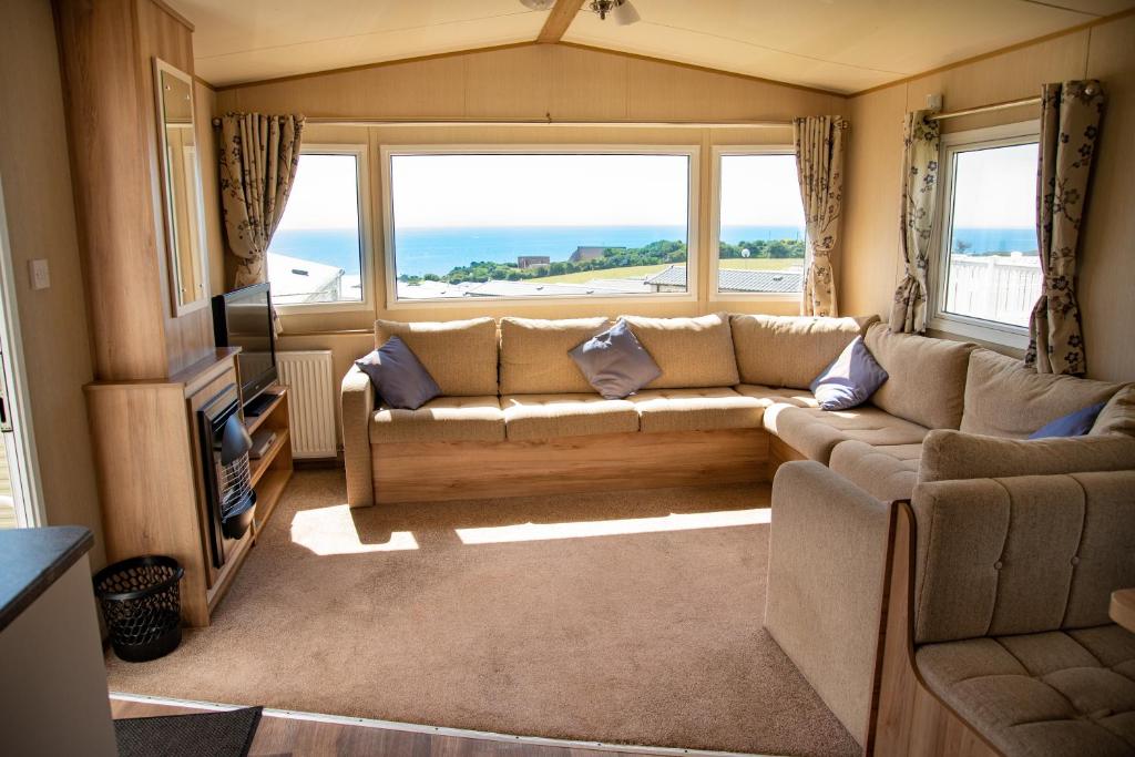 a living room with a couch and a large window at Devon Cliffs Holiday Home in Exmouth