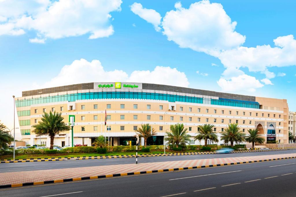 a large building in front of a road at Holiday Inn AlSeeb Muscat, an IHG Hotel in Muscat