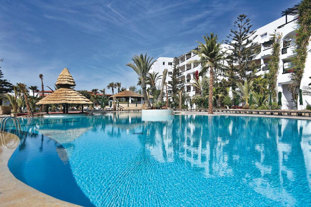 een groot blauw zwembad in een resort bij Hotel Riu Tikida Beach - All Inclusive Adults Only in Agadir