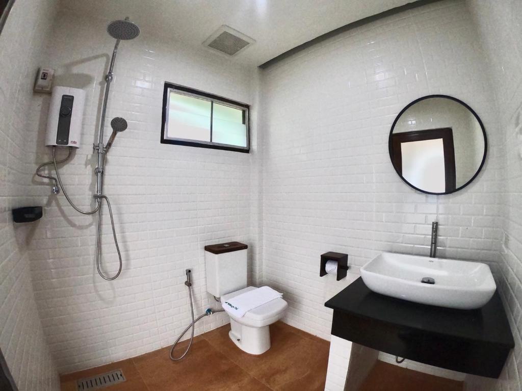 a bathroom with a sink and a toilet and a mirror at Diamond Village Pai in Pai