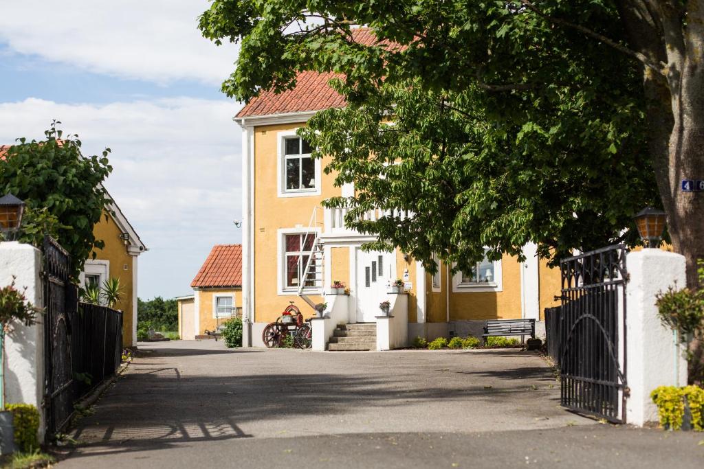 una casa amarilla con una puerta en una calle en Mjällbyhus Pensionat & Stugby en Sölvesborg