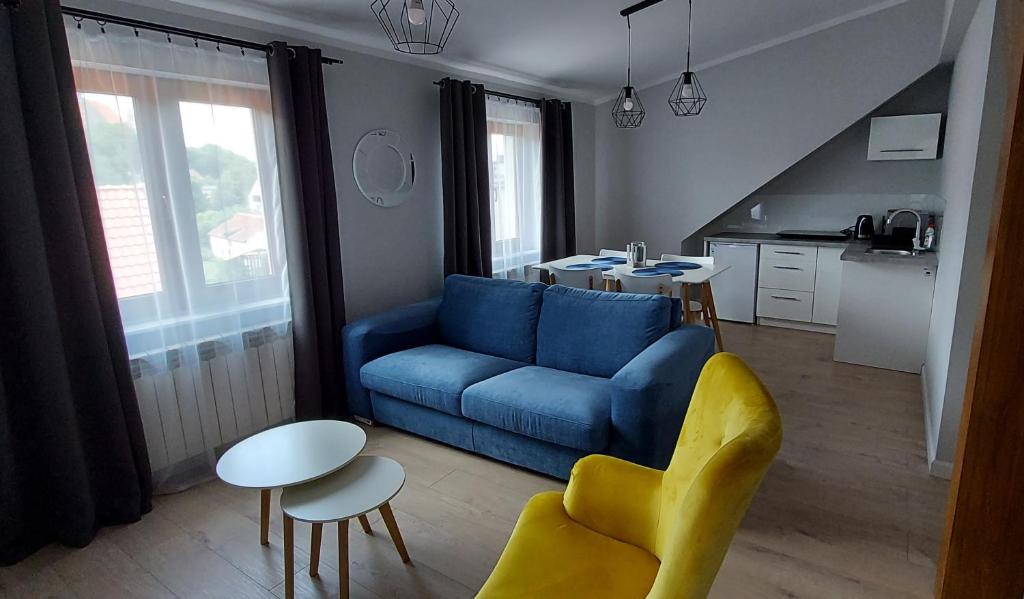 a living room with a blue couch and a table at Pokoje Gościnne Cztery Wiatry in Frombork