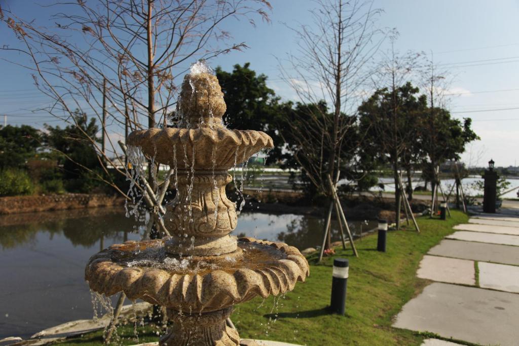 a stone fountain in front of a body of water at Happiness Pass On in Wujie