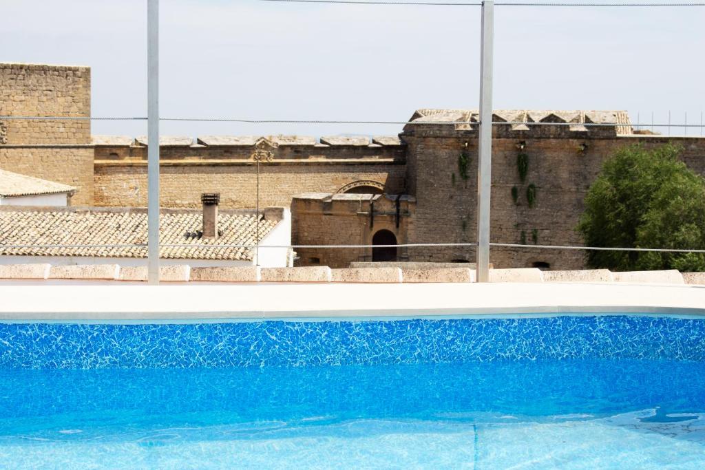 una piscina azul frente a un edificio antiguo en Hotel Rural Molino del Albaicín en Sabiote