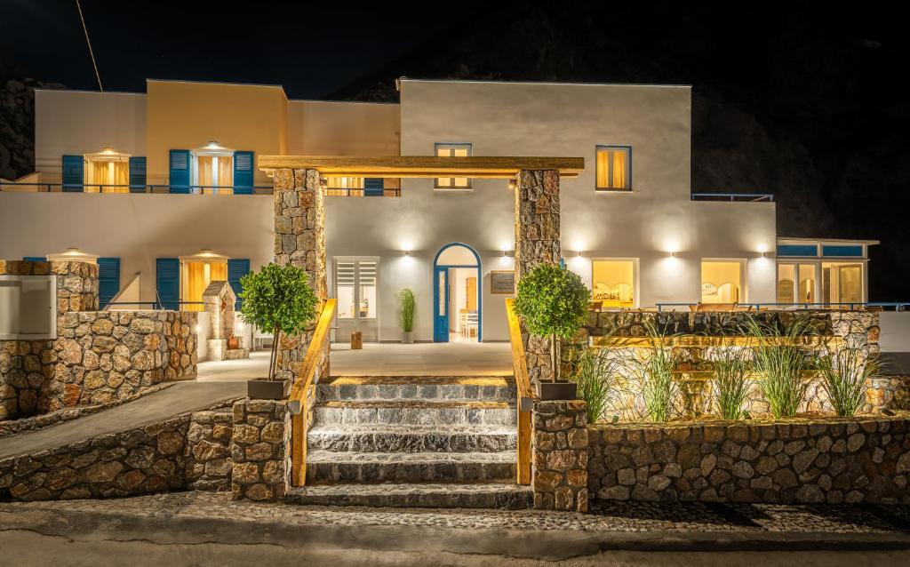 une maison avec un escalier devant elle la nuit dans l'établissement Marianna Hotel, à Perissa