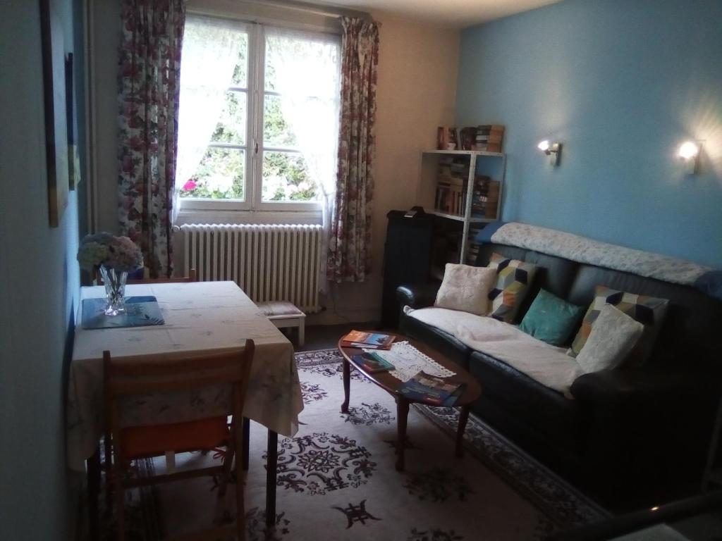 sala de estar con sofá y mesa en Lenard Charles Bed & Breakfast, en Juvigny-sous-Andaine