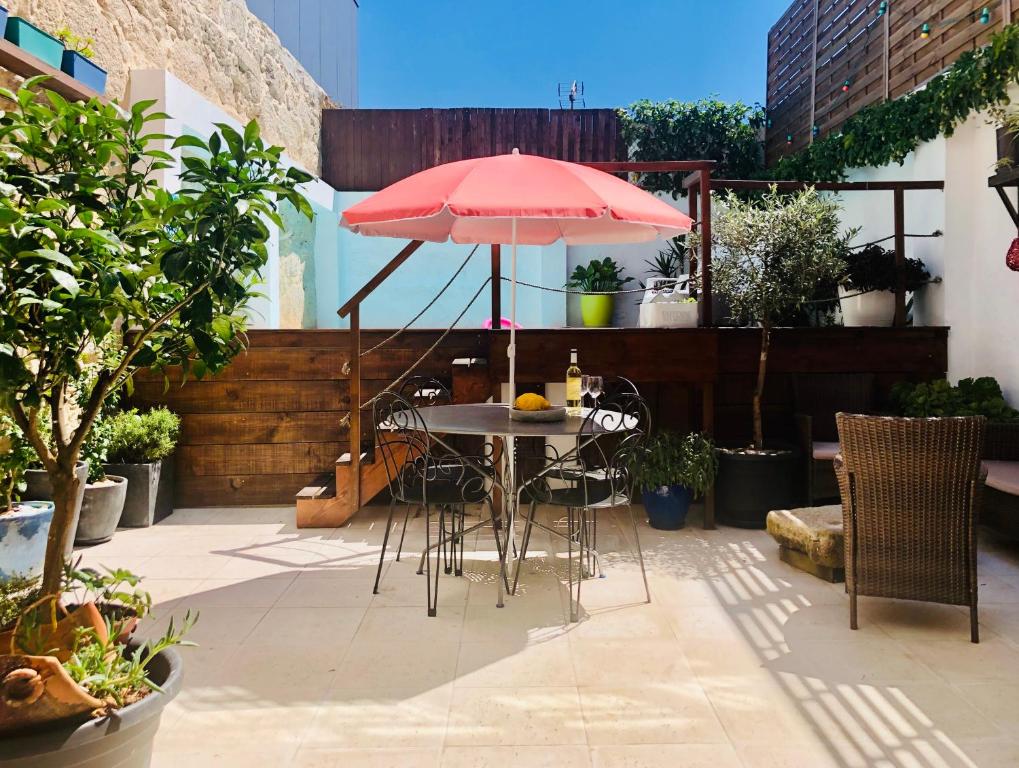 um pátio com uma mesa com um guarda-chuva vermelho em Boreal Porto Gaia - Patio & Pool em Vila Nova de Gaia