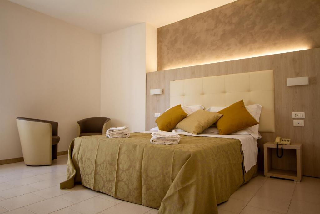 een slaapkamer met een groot bed met gele kussens bij Falcon Hotel in SantʼAgata Feltria
