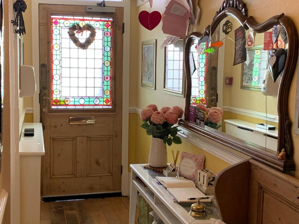 uma casa de banho com um lavatório, um espelho e uma janela em Chiltern Holiday apartments em Whitby