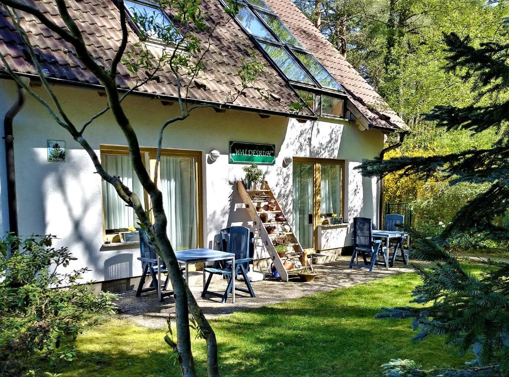 a house with chairs and a table in the yard at Haus Waldesruh in Lubmin