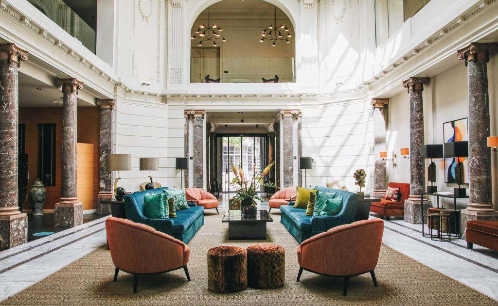 a lobby with couches and chairs and a mirror at Hotel FRANQ in Antwerp