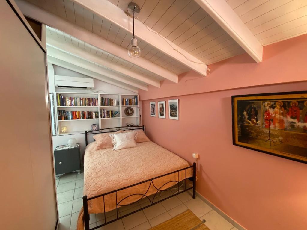 a bedroom with a bed in a room with pink walls at the bougainvillea house in Symi