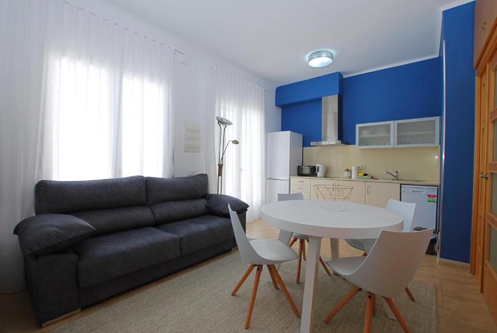 een woonkamer met een bank en een tafel en stoelen bij La Platgeta · La Platgeta · Ideal family apartment, with private terrace in Vilassar de Mar