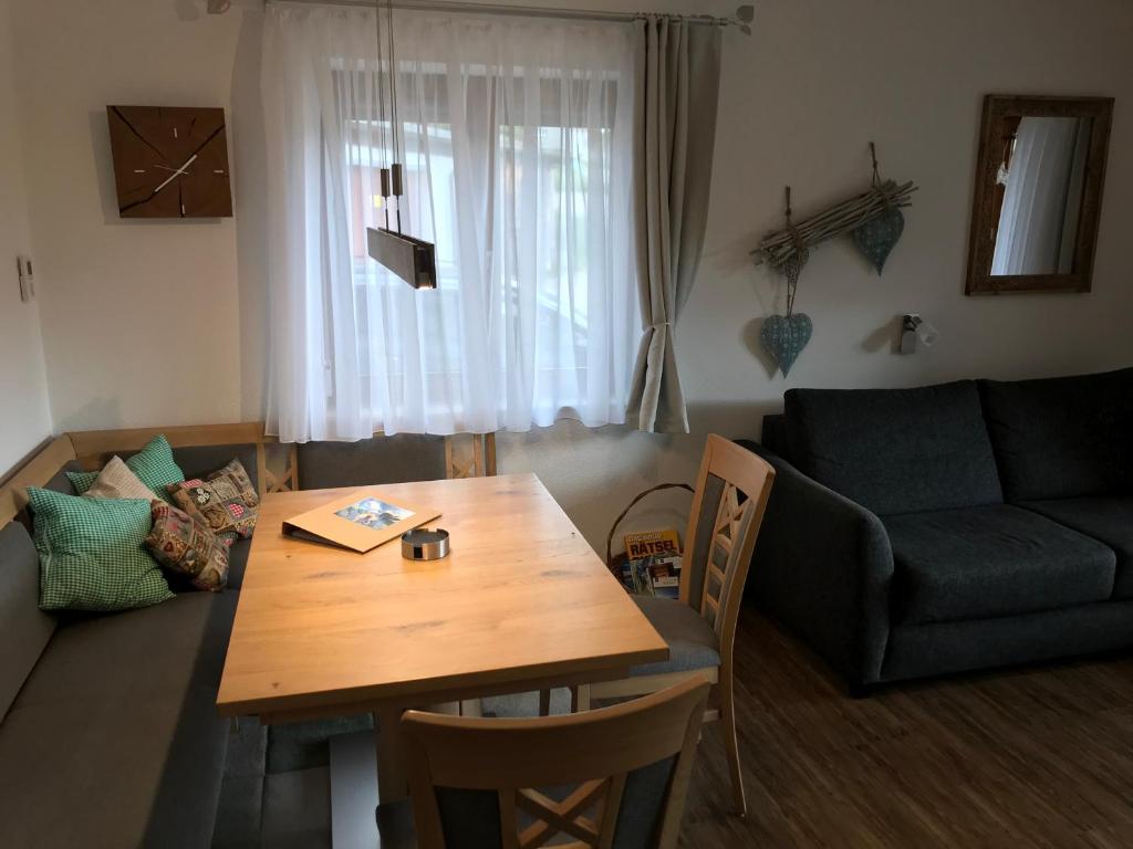 uma sala de estar com uma mesa de madeira e um sofá em Almblick Ferienwohnung em Balderschwang
