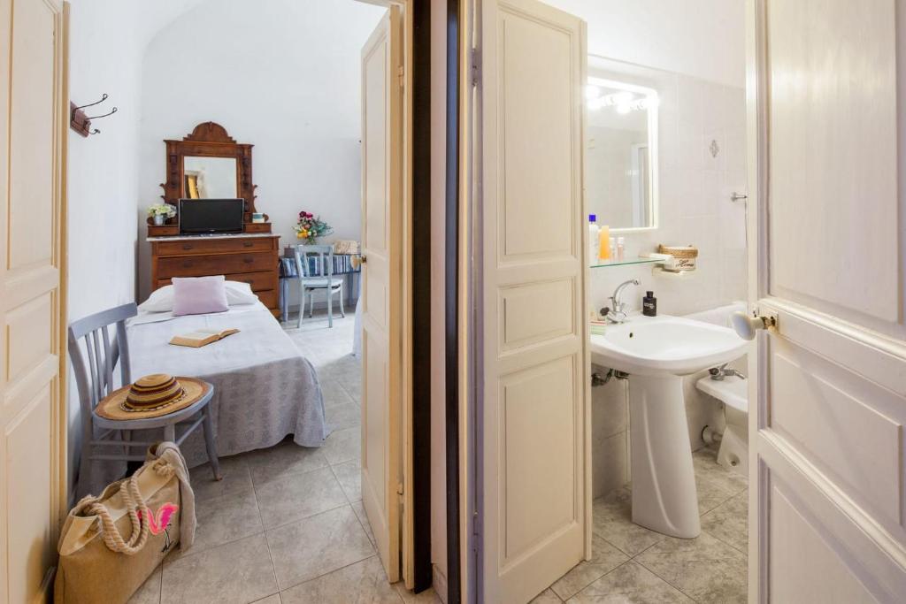 baño con lavabo y habitación con cama en Hotel Mimosa, en Alassio