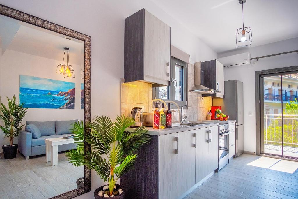 a kitchen with white cabinets and a living room at Serenity Luxe Suites in Parga