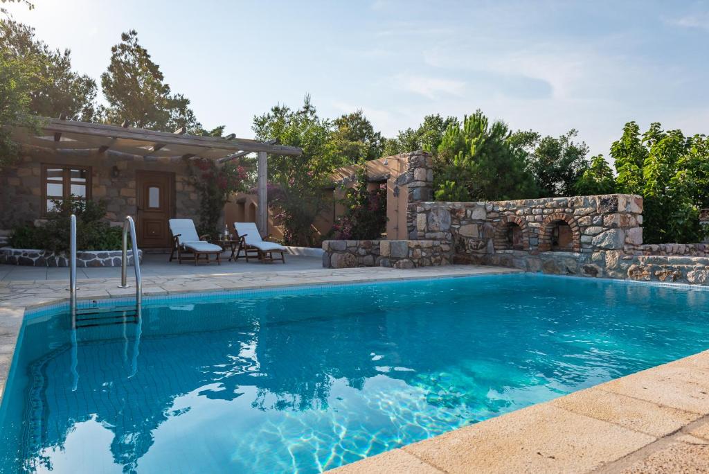 a swimming pool with a patio and a house at Blue Vista Patmos pool studio in Patmos