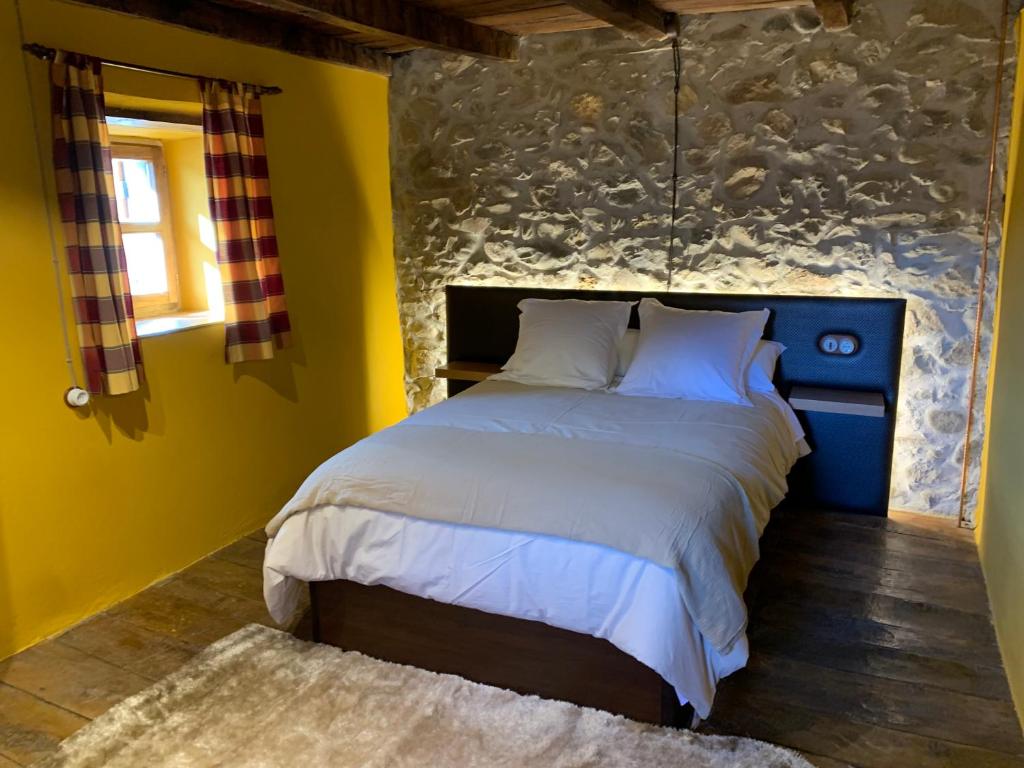 1 dormitorio con 1 cama grande y paredes amarillas en Casa Rural La Costurera en Los Espejos de la Reina