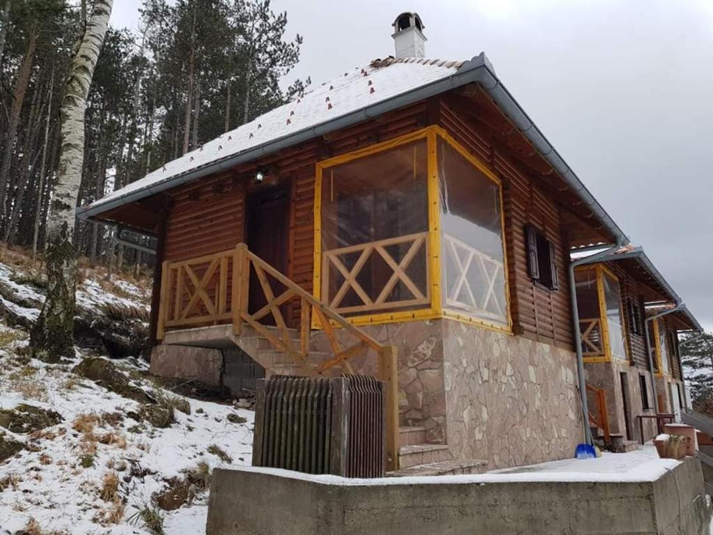 Cabaña de madera en la nieve con ventana grande en Brvnara Jovicic en Divčibare