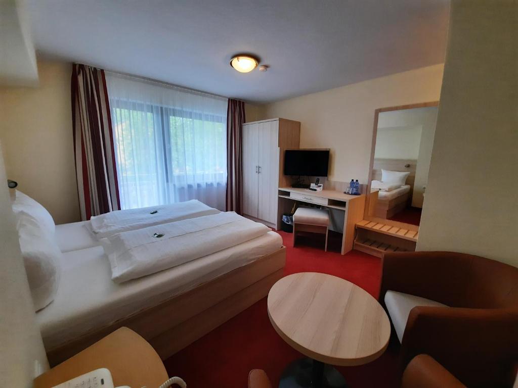 a hotel room with a large bed and a desk at Pension Beck Hotel in Bad Waldsee