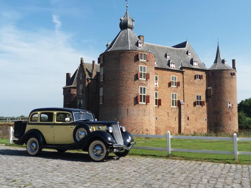 een oude auto geparkeerd voor een kasteel bij B&B kasteel Ammersoyen in Ammerzoden