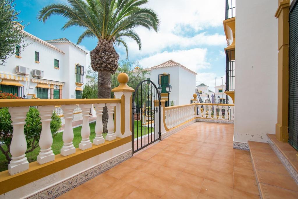 einen Balkon mit einem Zaun und einer Palme in der Unterkunft 071 Molino Blanco Beach - Alicante Holiday in La Mata