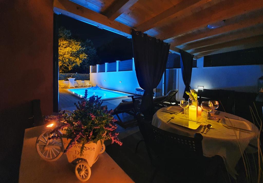 a dining room with a table and a swimming pool at Villa with a heated Pool near Split with Magnificent View in Solin
