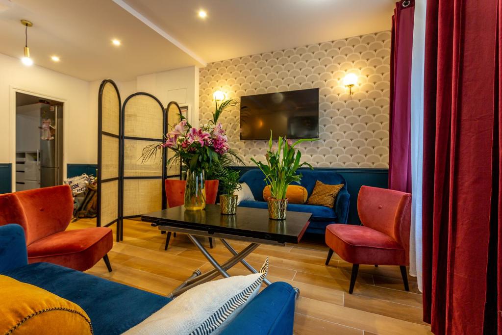 - un salon avec un canapé bleu et des fauteuils rouges dans l'établissement Hotel Europe BLV, à Paris