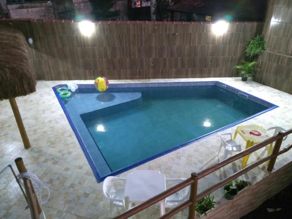 uma piscina com uma bola no meio em Residencial Villa Nova SUITE em Boiçucanga