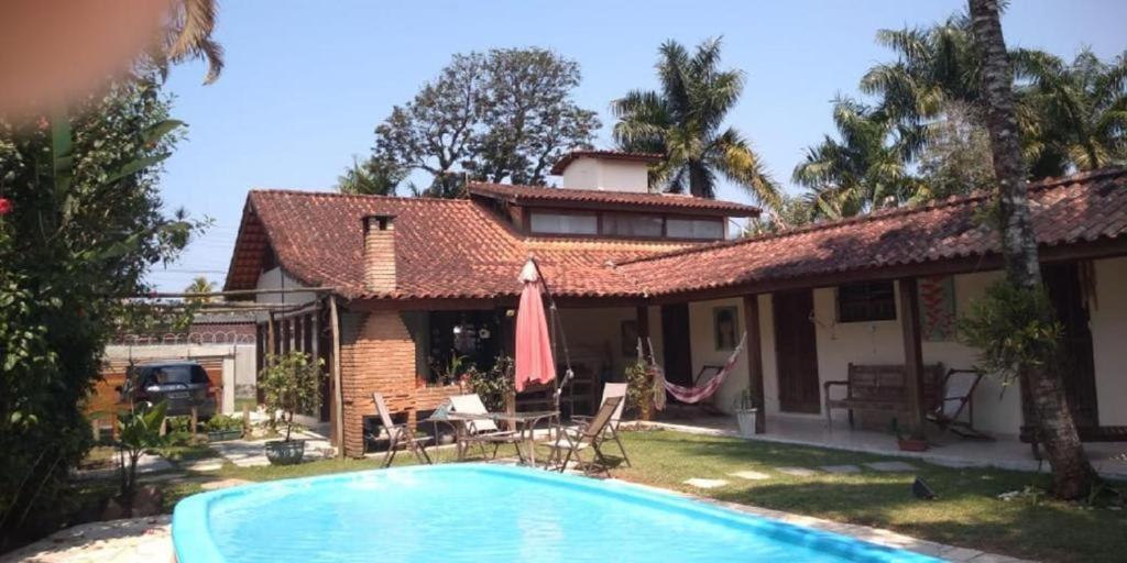 una casa con piscina frente a ella en Viver Ubatuba, en Ubatuba