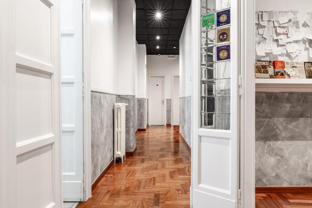 un corridoio con pareti bianche e pavimento in legno massello di Toledostop a Napoli