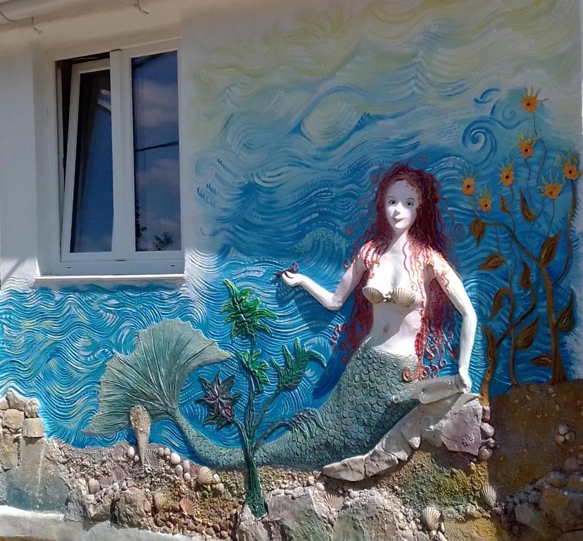 a mural of a girl sitting on the side of a building at Apartman SIRENA in Pićan