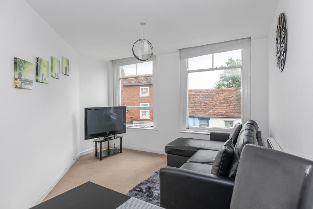 a living room with a couch and a television at Cosy One Bedroom Apartment in Worcester